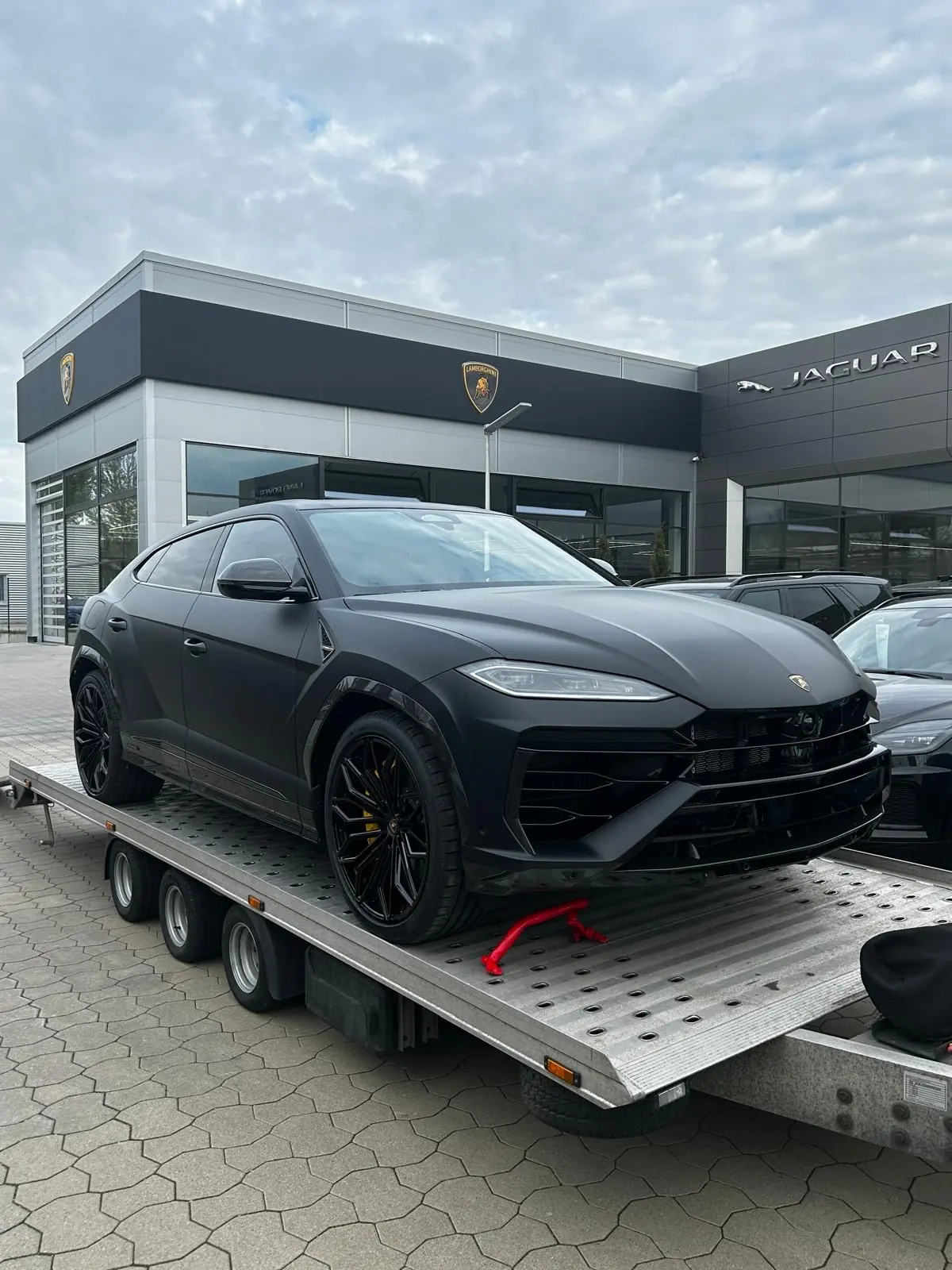 Schwarzer Lamborghini Urus auf einem Transportanhänger