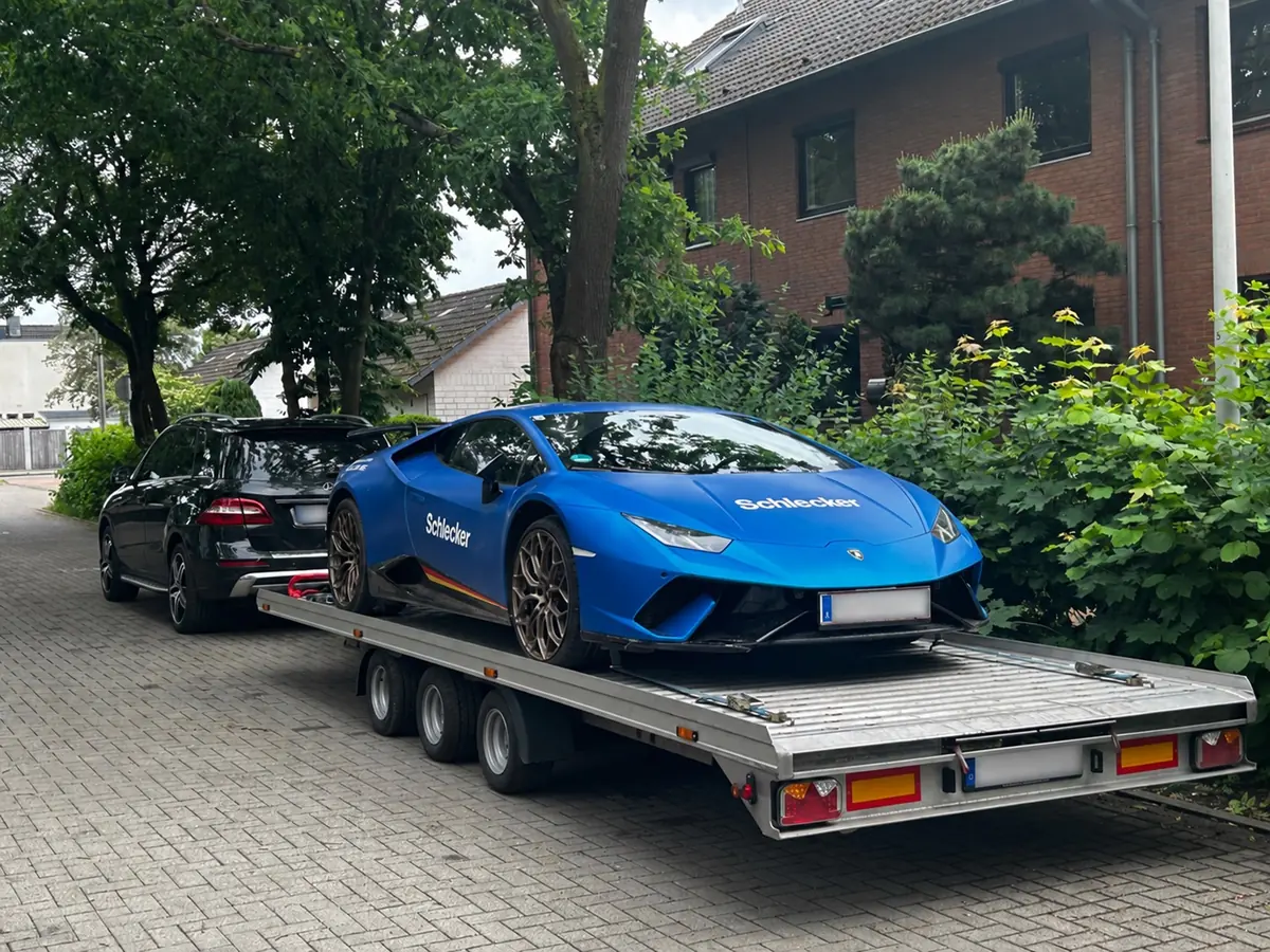 Blauer Lamborghini auf einem dreiachsigen Transportanhänger